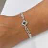 Close-up of the Nano Bible Bracelet on the wrist, square sterling silver Tanakh pendant centered on a Cuban link chain for everyday wear